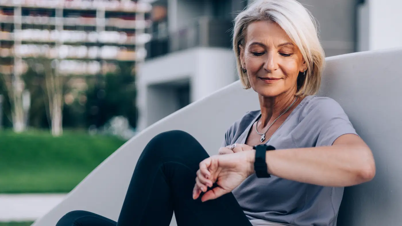 Senior using AI-powered health monitoring device at home with smart technology for health tracking and safety